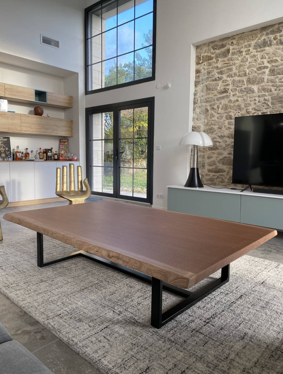 Grande table basse de luxe en bois massif avec bords bruts naturels live-edge et pieds en métal design à Paris